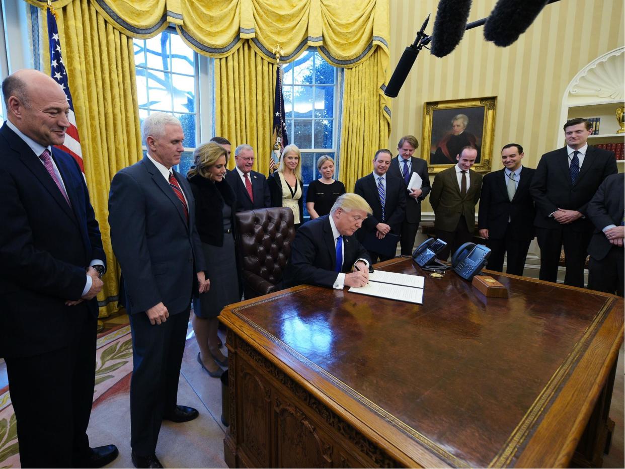 US President Donald Trump signs an executive order on ethics commitments by the executive branch appointees in the Oval Office on 28 January 2017: Getty