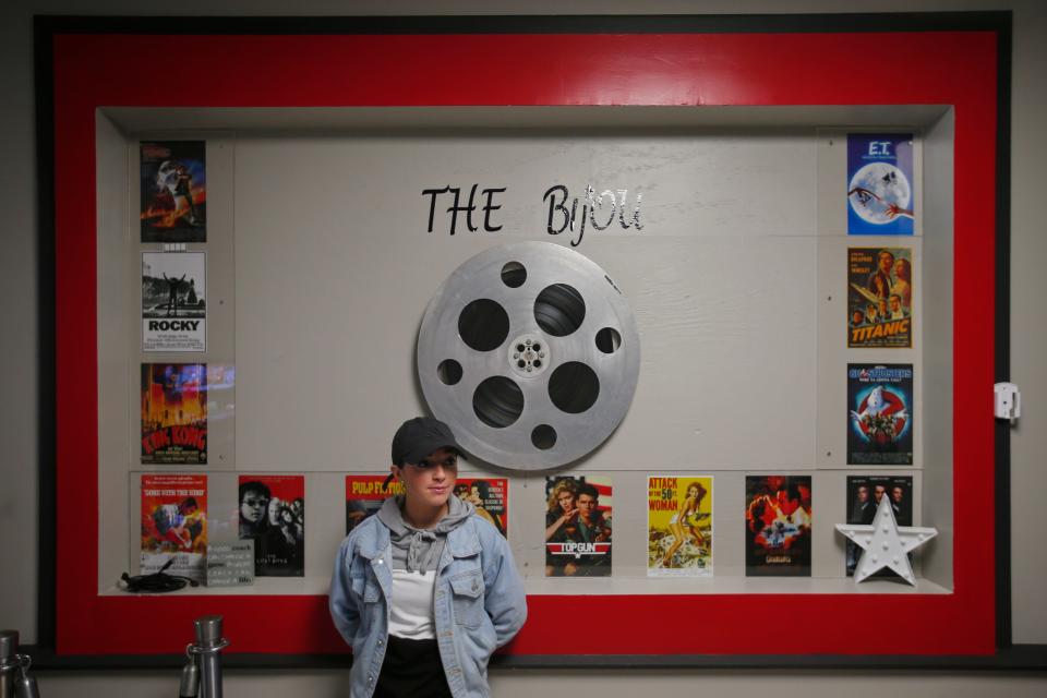 Personal trainer Braley Freire of B. Balanced Fitness stands in front of a wall dedicated to the former Bijou Theater on Main Street in Fairhaven which is now a person trainer gym