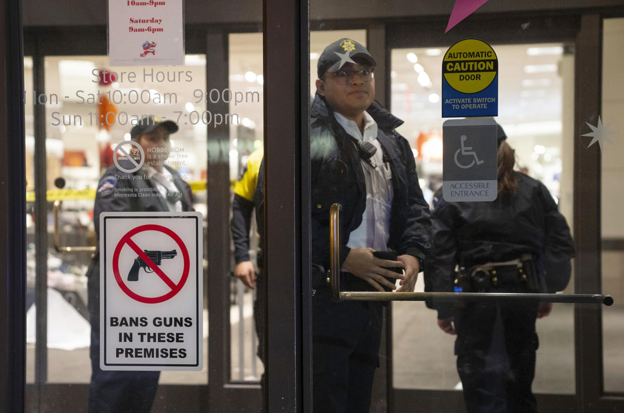 Officials lock down the west wing of the Mall of America after a shooting was reported, Friday, Dec. 23, 2022 in Bloomington, Minn. A shooting sent the Mall of America into lockdown Friday evening, mall officials and police in suburban Minneapolis said. (Alex Kormann/Star Tribune via AP)
