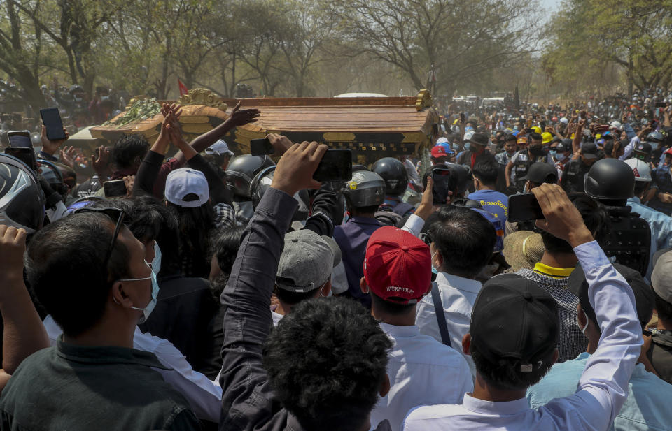 FILE - In this Thursday, March 4, 2021 file photo, a crowd gathers as a hearse carrying the body of 19-year-old Kyal Sin, also known as Angel, arrives at a cemetery in Mandalay, Myanmar. Kyal Sin was shot in the head during an anti-military takeover rally she was attending the previous day. Authorities released a death certificate saying the bullet that killed her didn’t match the caliber used by police, that it came from the wrong direction for security forces to be responsible, and blamed protesters for her death. However, local news reports and social media accounts said security forces were firing live rounds. (AP Photo)