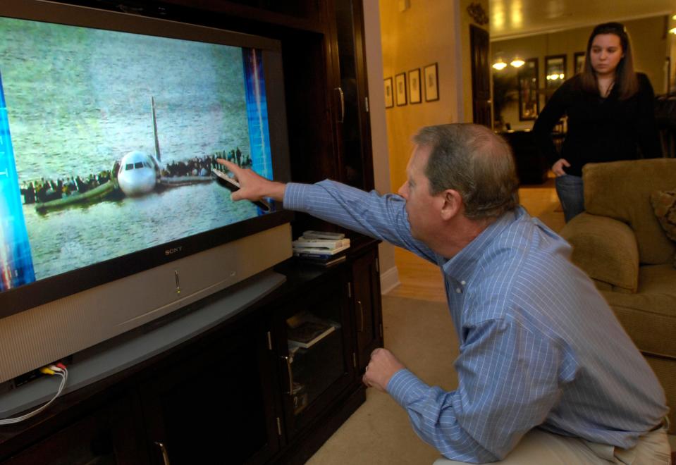 Casey Jones points to himself standing on the wing of U.S. Airways Flight 1549 that splash-landed into the Hudson River in New York a day earlier as he and his daughter Mandy (background) watch a news report on the television screen Jan. 16, 2009, at his home in St. Johns County, Florida. He and all others aboard survived the "Miracle on the Hudson."