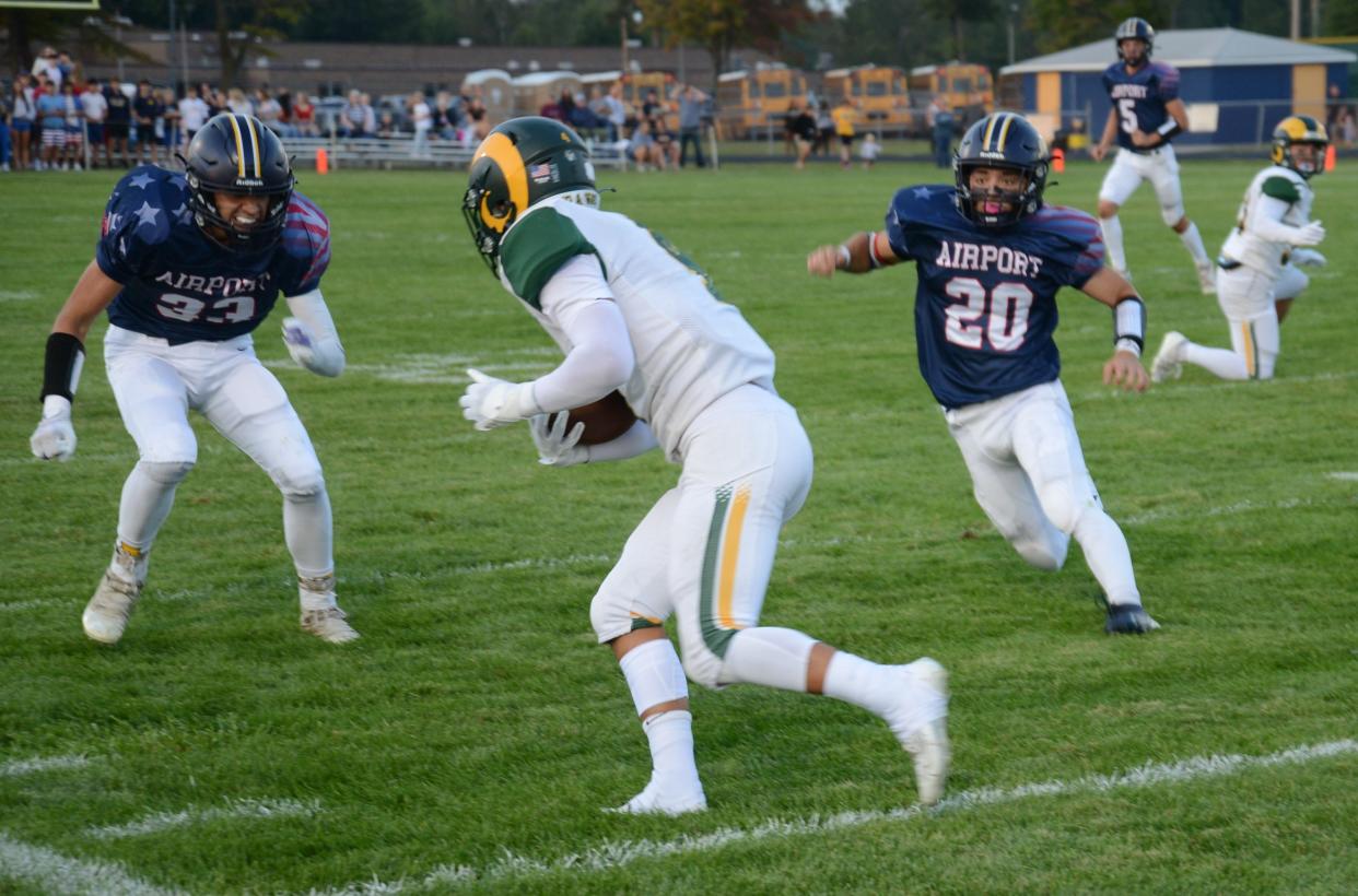 Flat Rock's Braylen Crump is hemmed in by Airport defenders Ryan Hildebrand (left) and Tyler Carroll on Friday, Sept. 13, 2024.