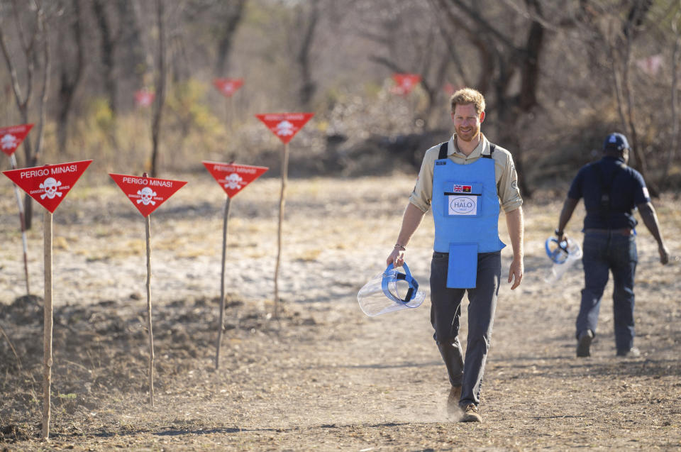 Britain's Prince Harry walks through a minefield in Dirico, Angola Friday Sept. 27, 2019, during a visit to see the work of landmine clearance charity the Halo Trust, on day five of the royal tour of Africa. Prince Harry is following in the footsteps of his late mother, Princess Diana, whose walk through an active mine field in Angola years ago helped to lead to a global ban on the deadly weapons. (Dominic Lipinski/Pool via AP)