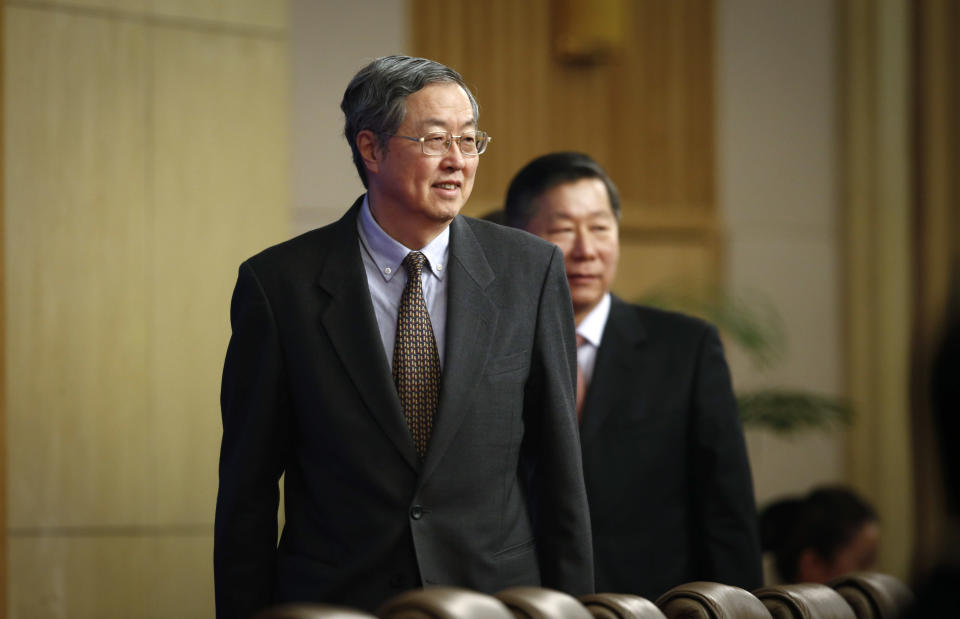 People's Bank of China governor Zhou Xiaochuan, left, arrives for a press conference held for the National People's Congress at the media center in Beijing, China, Tuesday, March 11, 2014. Zhou said Beijing might finish the process of easing controls on interest rates within two years and market forces will set the pace for allowing use of its tightly controlled currency abroad. (AP Photo/Vincent Thian)