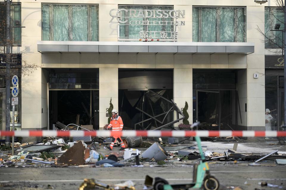 A firefighter walks through debris in front of a hotel where a huge aquarium has burst in Berlin, Germany, December 16, 2022. / Credit: Markus Schreiber/AP