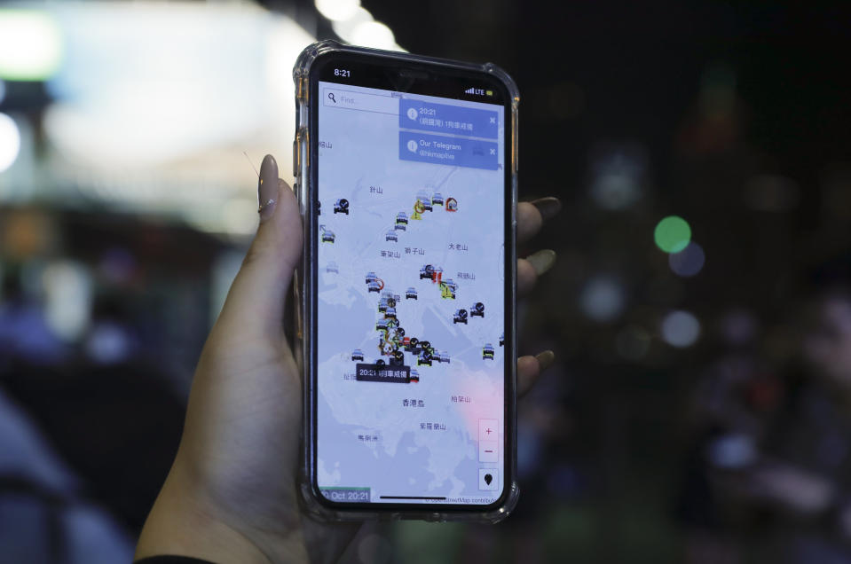 A person's phone shows HKmap.live apps as they join others at a rally to mark Taiwan's National Day, in the Tsim Sha Tsui district in Hong Kong, Thursday, Oct. 10, 2019. A Hong Kong government official said on Thursday that Apple was responsible for removing a smartphone application which allowed activists to report police movements. (AP Photo/Kin Cheung)