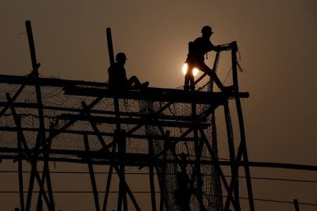 Workers build scaffolding at a construction site on a hazy day in Beijing, China, December 31, 2016. REUTERS/Thomas Peter