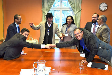 At left, Abdelqader al-Murtada and Saelem Mohammed Noman Al-Mughalles, representatives of the Ansar Allah delegation and at right, Askar Zaeil and Hadi al-Hayi representing the delegation of the Government of Yemen react at the negotiating table together with representatives from the office of the U.N. Special Envoy for Yemen and the International Red Cross Committee (ICRC) when lists of prisoners are exchanged, a first step to implement the agreement to release all prisoners by the two parties, during the ongoing peace talks on Yemen held at Johannesberg Castle, in Rimbo, near Stockholm, Sweden, December 11, 2018. TT News Agency/Claudio Bresciani via REUTERS