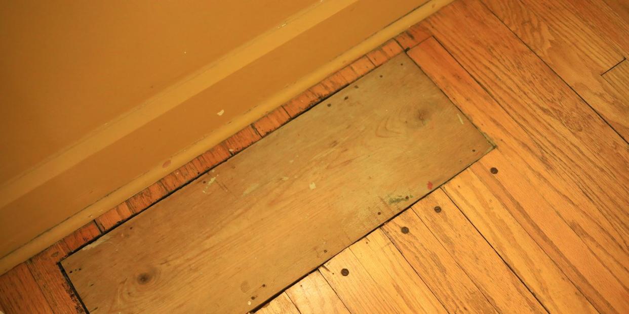 words board covering a hole in the hardwood floor