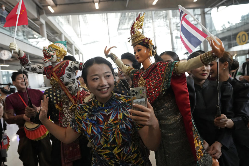 Chinese tourists dance with puppet as they are welcomed on arrivals at Suvarnabhumi International Airport in Samut Prakarn province, Thailand, Monday, Sept. 25, 2023. Thailand's new government granting temporary visa-free entry to Chinese tourists, signaling that the recovery of the country's tourism industry is a top economic priority. (AP Photo/Sakchai Lalit)