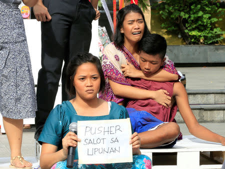 Filipino theatre artists perform a short musical about the killings under the Philippine government's anti-drug campaign, in Pandacan city, metro Manila, Philippines April 2, 2017. The placard reads, (drug) "pusher a menace to the society". REUTERS/Romeo Ranoco