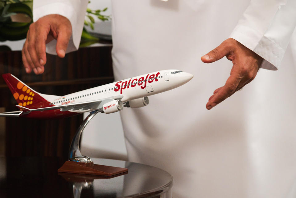 An Emirati man reaches out for a model of a SpiceJet airliner in Ras al-Khaimah, United Arab Emirates, Wednesday, Oct. 23, 2019. India's low-cost airline SpiceJet announced plans Wednesday to build its first international hub in the United Arab Emirates, offering a pledge of support to Boeing Co. by saying it would use now-grounded 737 MAX aircraft in the operation once regulators approve the planes for flight. (AP Photo/Jon Gambrell)