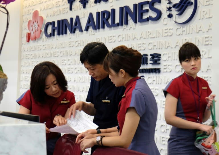 Ground staff of China Airlines check the latest information at the front desk during industrial action by cabin crew, in Taipei, on June 24, 2016