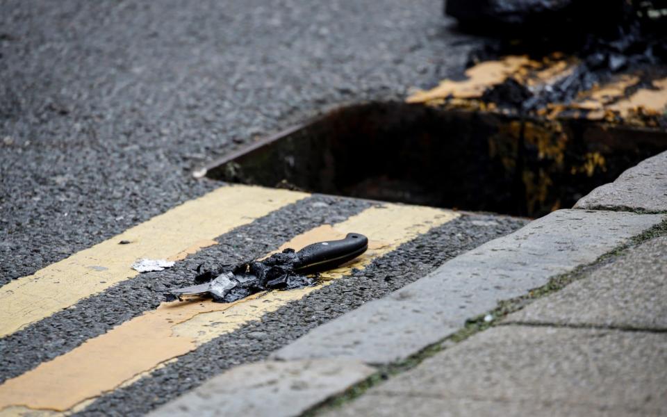 A knife lies on the pavement after being recovered by the police from a drain following reported stabbings in Birmingham - REUTERS/Phil Noble