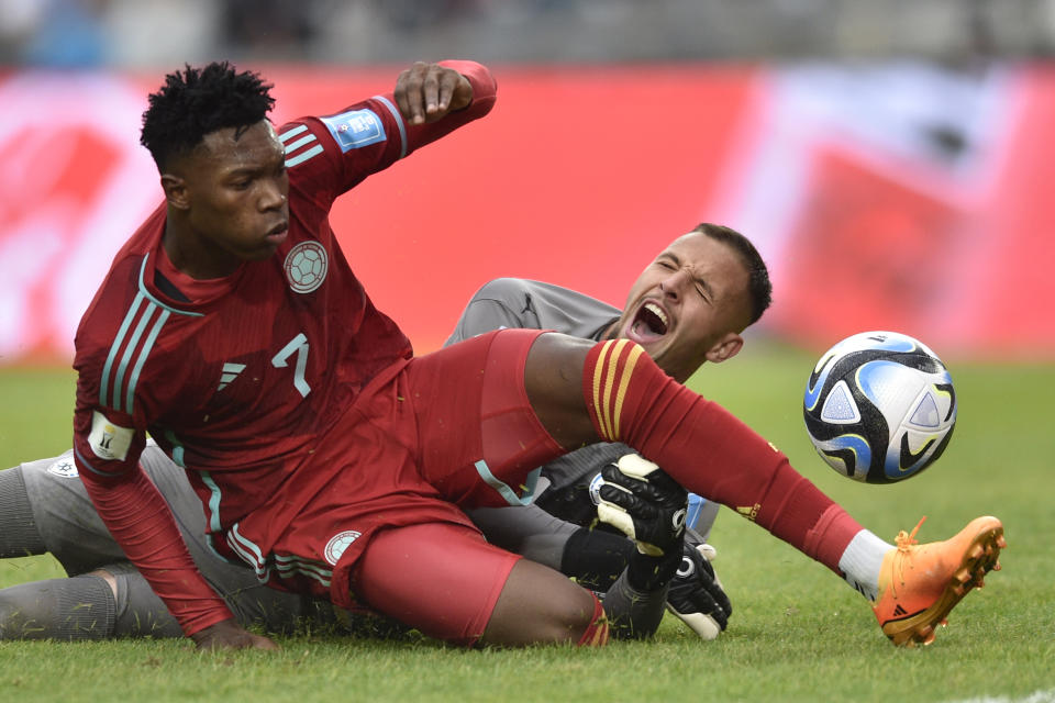 Colombia's Jorge Cabezas fights for the ball with Israel's goalkeeper Tomer Zarfati, right, during a FIFA U-20 World Cup group C soccer match at Diego Maradona stadium in La Plata, Argentina, Sunday, May 21, 2023. (AP Photo/Gustavo Garello)