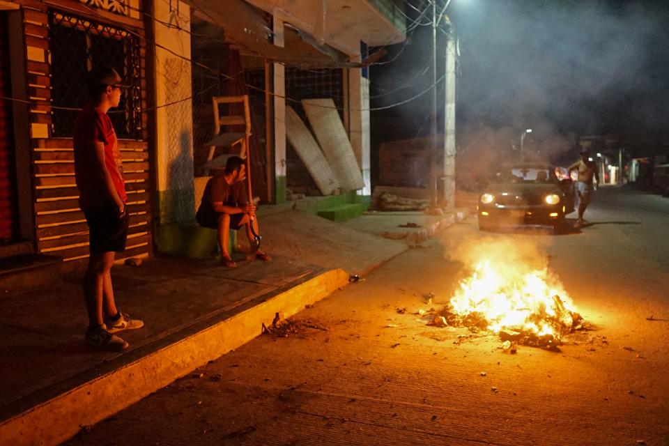 Los residentes del barrio Progreso resguardan una calle como medida de seguridad tras saqueos e inseguridad posteriores al paso del huracán Otis por Acapulco, estado de Guerrero, México, el 30 de octubre de 2023. Otis impactó la ciudad portuaria temprano el 25 de octubre con vientos de 270 kilómetros por hora, dejando un rastro de destrucción. La tormenta dañó gravemente o destruyó numerosos edificios y causó apagones de energía y comunicaciones. Las estanterías de los supermercados se vaciaron rápidamente en una ola de saqueos. (Foto de SILVANA FLORES / AFP) (Foto de SILVANA FLORES/AFP a través de Getty Images)