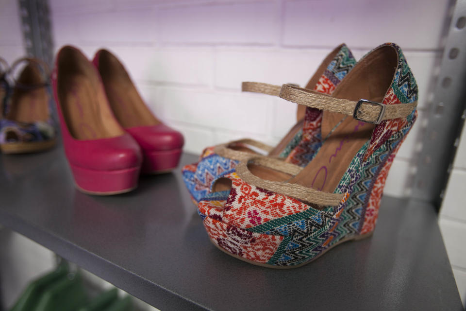 In this Aug, 21, 2013 photo, a pair of wedges show toes designed by Karim Corzo with embroidered Guatemaln fabric, sit on a shelf at a factory where the shoes are handmade in Guatemala City. Embroidered Mayan textiles known as huipiles are undergoing a revival in some of the country’s finest boutiques as they become a haute couture fixture. Young Guatemalan designers are using them for everything from evening gowns and purses to handmade shoes sold as far away as Dubai. (AP Photo/Luis Soto)