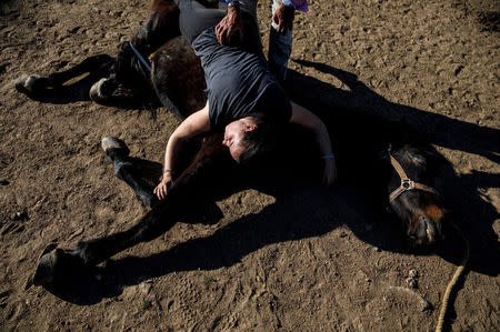 Fernando Noailles, emotional therapist, and his patient Maria Lopez Herraiz attend an emotional therapy session with a horse named Madrid in Guadalix de la Sierra, outside Madrid, Spain, April 27, 2018. Noailles uses his animals to help people suffering from stress and anxiety. REUTERS/Juan Medina