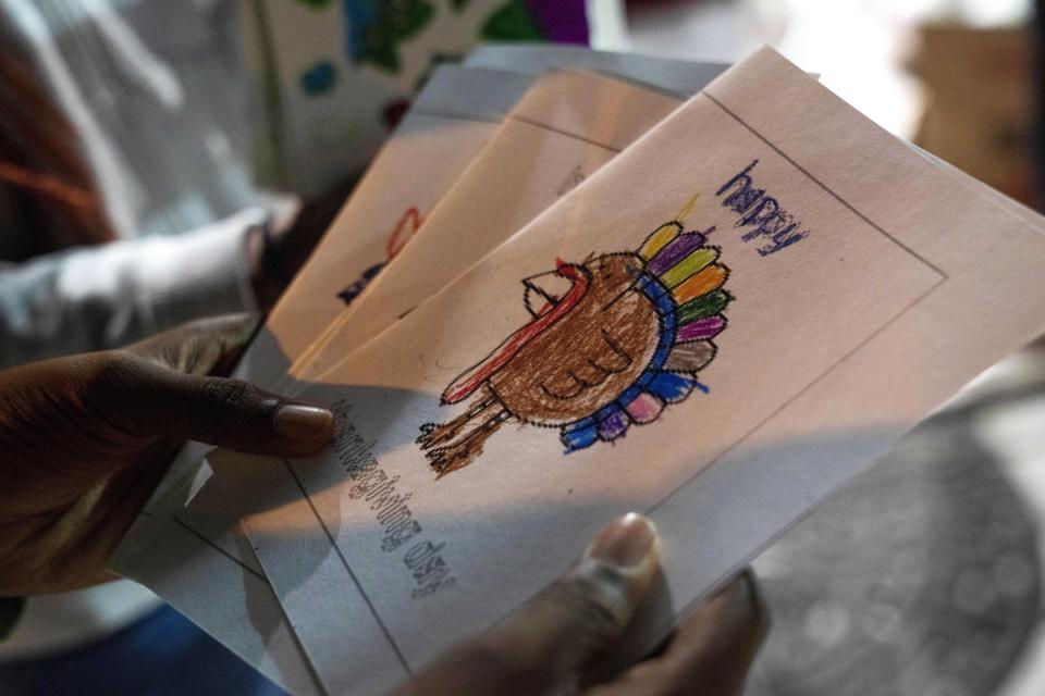 Volunteers pass out Thanksgiving cards decorated by children in the congregation, during an annual Thanksgiving food giveaway at The Redeemed Christian Church of God New Wine Assembly, Tuesday, Nov. 22, 2022, in Washington. (AP Photo/Jacquelyn Martin)