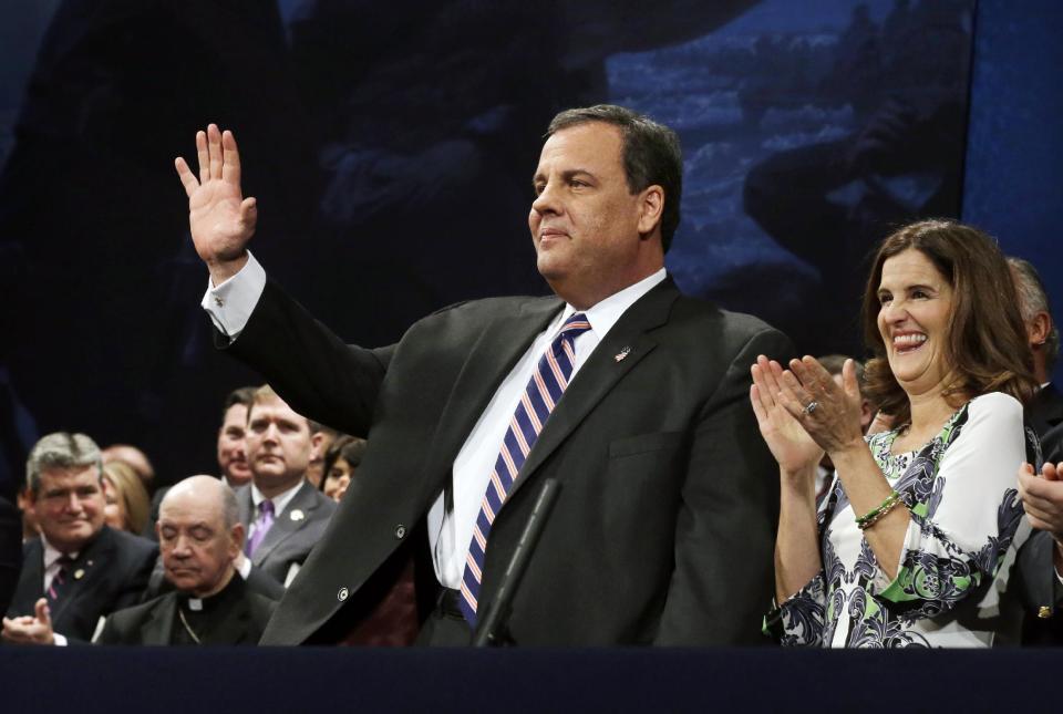 In this Jan. 21, 2014, photo, New Jersey Gov. Chris Christie waves as he stands with his wife Mary Pat Christie during a gathering for his swearing in for his second term in Trenton, N.J. As controversy grows around Christie, he’s finding support in the nation’s Hispanic community. Some minority leaders usually aligned with Democrats are giving the Republican governor the benefit of the doubt. They’re willing to support Christie, in part, because he has aggressively courted Hispanic voters throughout his first term. (AP Photo/Mel Evans)