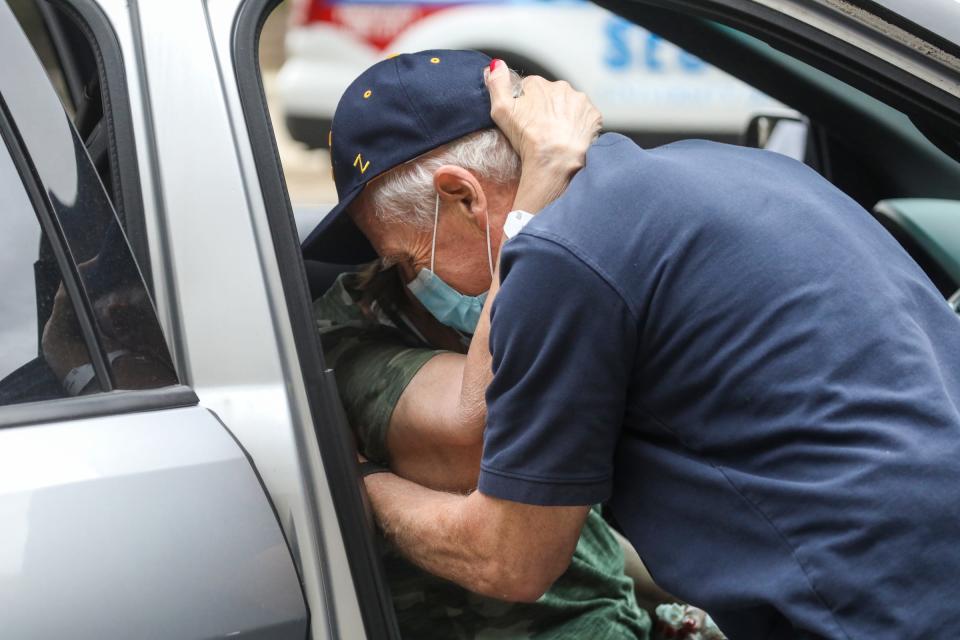 Deanna Hair embraces her husband Ken Hair as he whispers "You made it" placing her in the car after being discharged from the University of Michigan hospital battling COVID-19 for 196 days on Oct. 15, 2020.