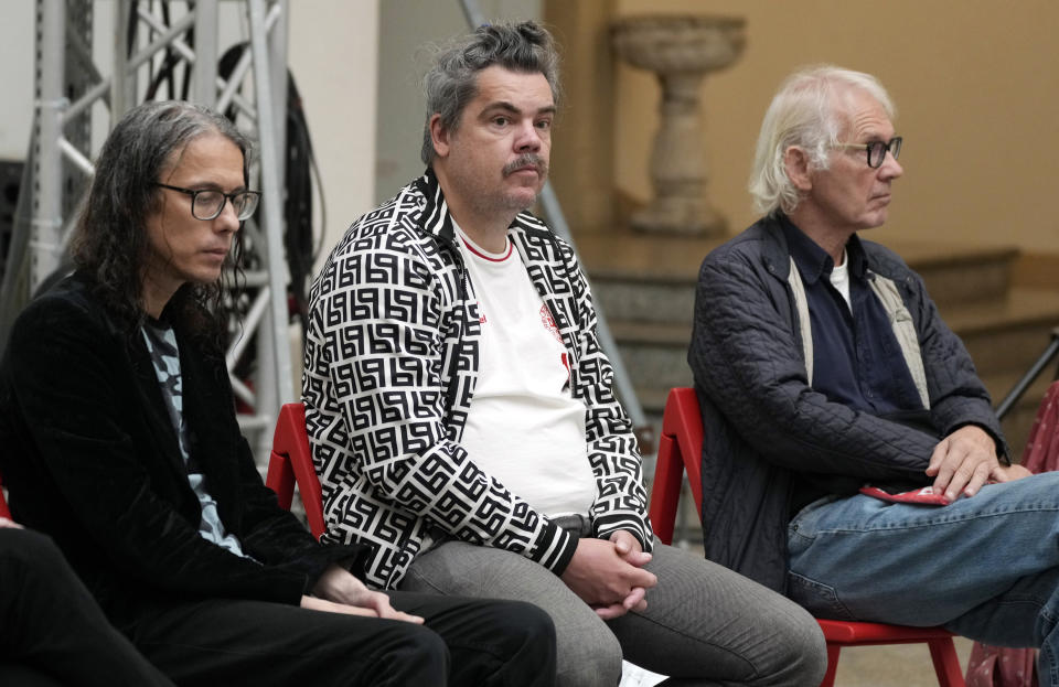 Artists Dan Park,left, Uwe Max Jensen and Lars Vilks listen ,right, during a news conference ahead of the opening of an exhibition in Warsaw, Poland, on Friday Aug. 27, 2021. The exhibition titled "Political Art" which opens Friday at the Polish state museum features the works of provocative artists in what organizers describe as a celebration of free speech. Some critics, however, accuse the organizers of the show of giving a platform to anti-Semitic and racist messages. (AP Photo/Czarek Sokolowski)