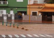 People watch from their homes a road flooded by the rain of the tropical storm Hermine, in Pozo Izquierdo