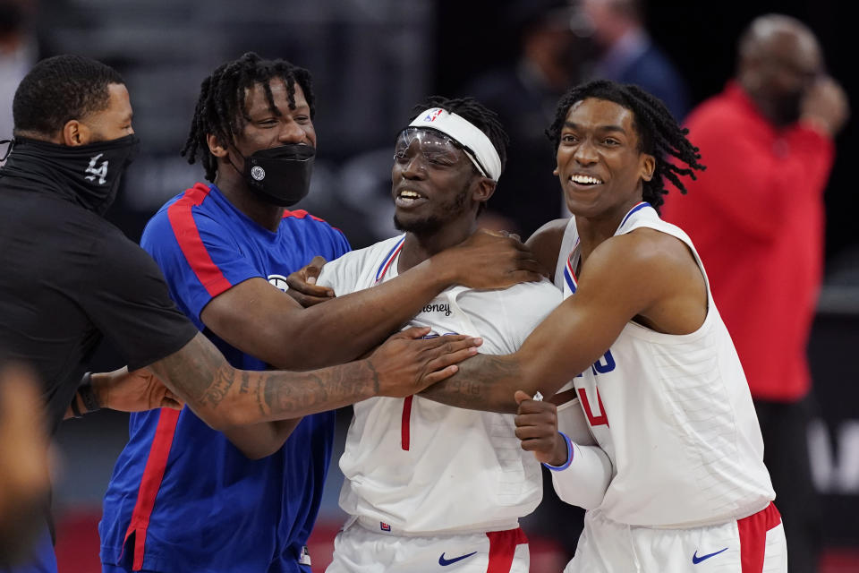 Los Angeles Clippers guard Reggie Jackson (1) is surrounded by teammates after hitting the game winning basket during the second half of an NBA basketball game against the Detroit Pistons, Wednesday, April 14, 2021, in Detroit. (AP Photo/Carlos Osorio)