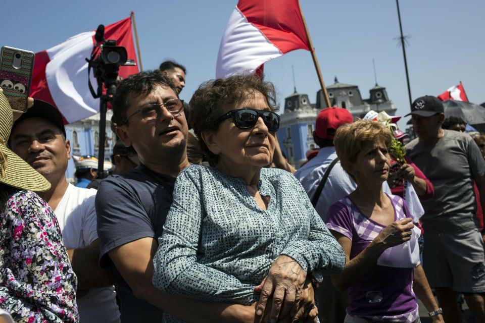 Supporters of Peru's late President Alan Garcia gather during his funeral procession in Lima, Peru, Friday, April 19, 2019. Garcia shot himself in the head and died Wednesday as officers waited to arrest him in a massive graft probe that has put the country's most prominent politicians behind bars and provoked a reckoning over corruption. (AP Photo/Rodrigo Abd)