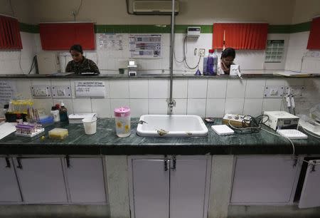 Hospital staff members work inside a laboratory at Janakpuri Super Speciality Hospital in New Delhi January 19, 2015. REUTERS/Adnan Abidi