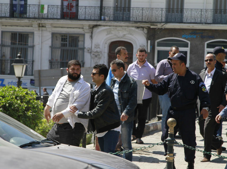 Algerian plainclothes police escort away a man involved in a brief protest in downtown Algiers during the presidential elections on April 17, 2014. Algerians head to the polls to elect a president in a contest widely expected to be won by 77-year-old incumbent Abdelaziz Bouteflika who is running for a fourth term. (AP Photo/Paul Schemm)