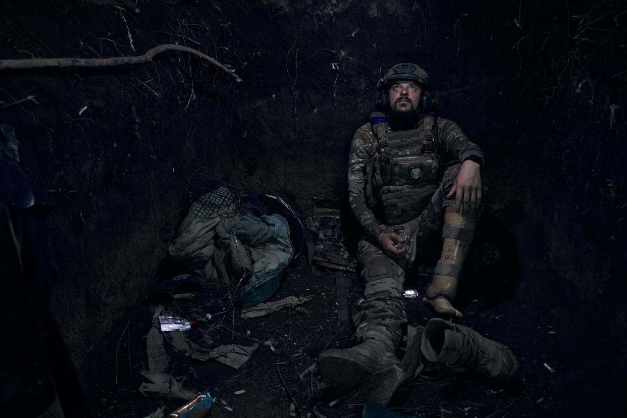 Ukrainian soldier, code name Molot (hammer), who lost his leg in a battle with the Russian troops and came back to the frontline with the prosthetic leg, sits in a trench on the frontline in the Zaporizhzhia region (AP)