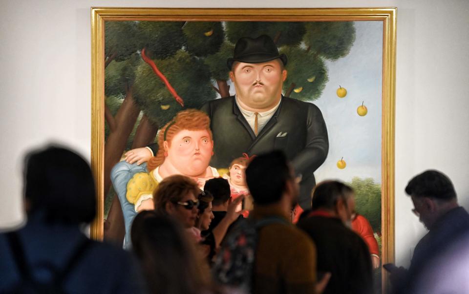 Visitors look at the painting "Una Familia" (A Family) by Colombian artist Fernando Botero at the Botero Museum in Bogota on Sept. 15, 2023.