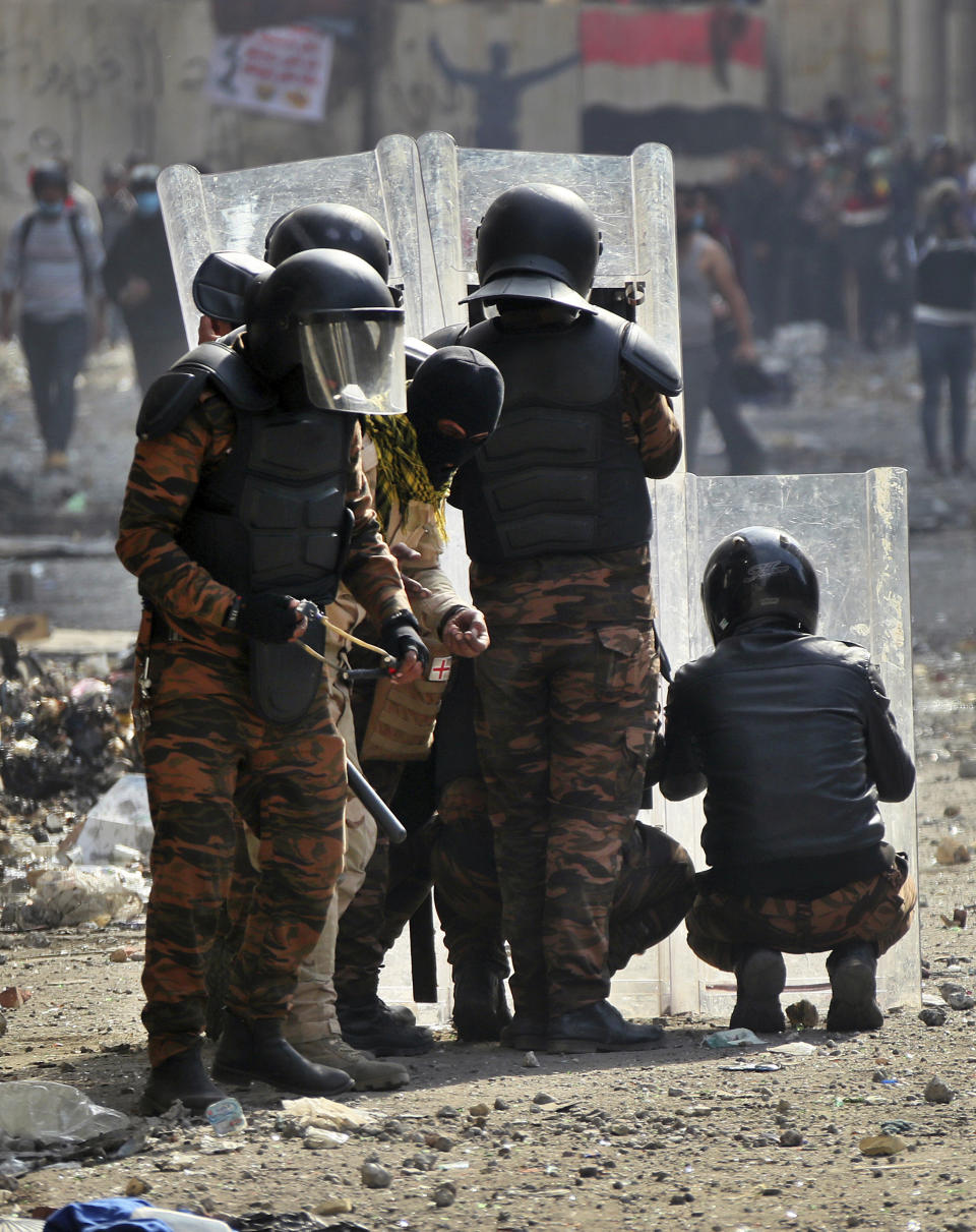 Riot police try to disperse anti-government protesters during clashes in Baghdad, Iraq, Saturday, Nov. 23, 2019. (AP Photo/Hadi Mizban)