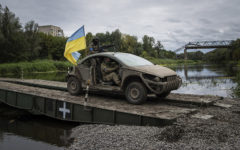 Ukrainian paratroopers drive in a vehicle with Ukrainian flag