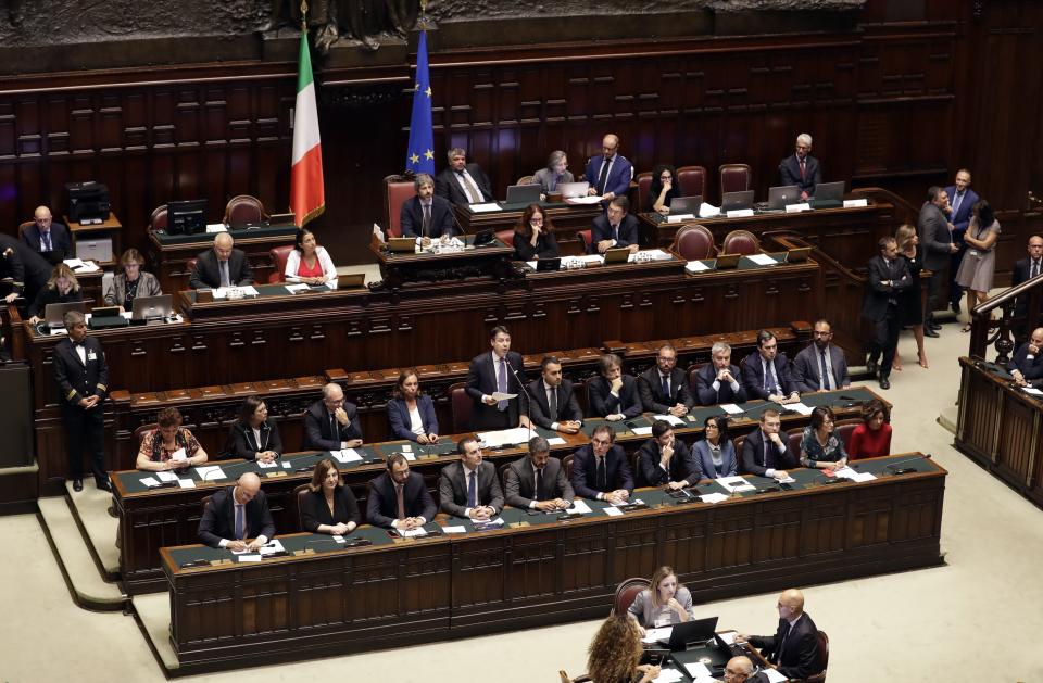 Italian Premier Giuseppe Conte, standing at center, sits with his cabinet ministers as he addresses parliament ahead of confidence vote later at the Lower Chamber in Rome, Monday, Sept. 9, 2019. Conte is pitching for support in Parliament for his new left-leaning coalition ahead of crucial confidence votes. (AP Photo/Andrew Medichini)