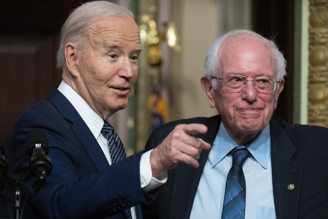 President Joe Biden gestures as Senator Bernie Sanders, Independent from Vermont, looks on during an event about lowering healthcare costs in the Indian Treaty Room of the White House in Washington, DC, on April 3, 2024.