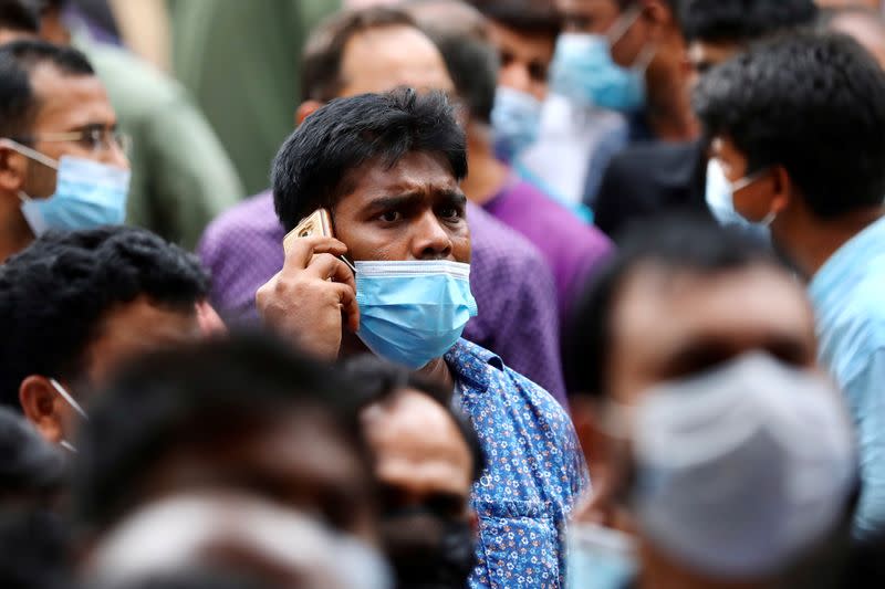 A stranded Bangladeshi worker talks over the cell phone as he waits outside of the Biman Bangladesh Airlines office, demanding flight tickets to go back to Saudi Arabia, in Dhaka