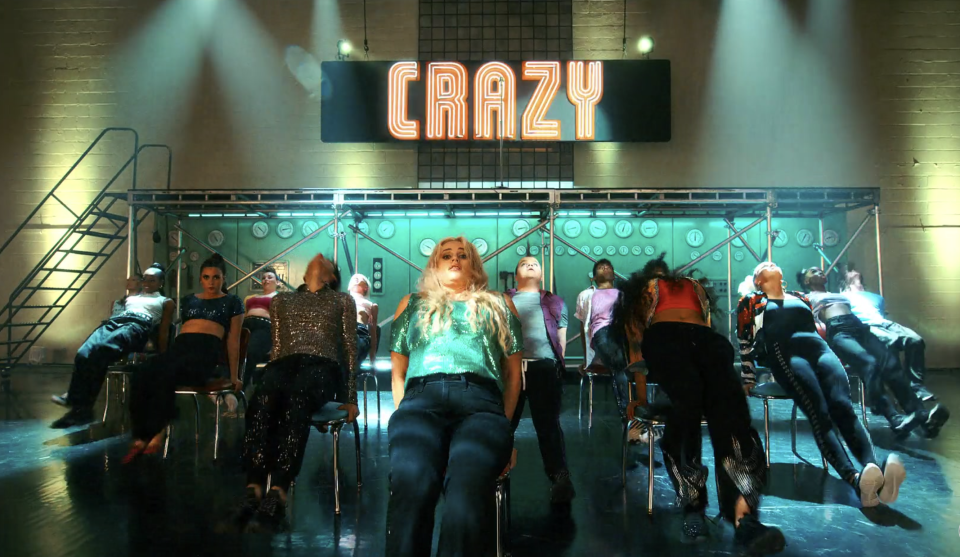 People leaning back in their chairs with a "Crazy" sign above them