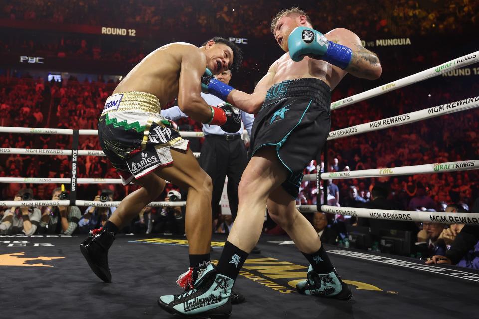 LAS VEGAS, NEVADA - MAY 04: Canelo Alvarez (R) lands a right on Jaime Munguia in the 12th round of their undisputed super middleweight championship fight at T-Mobile Arena on May 04, 2024 in Las Vegas, Nevada. Alvarez retained his titles in a unanimous decision. (Photo by Christian Petersen/Getty Images)