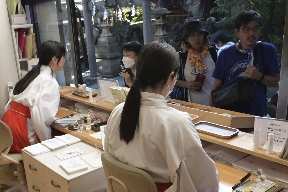 Shrine maidens prepare Goshuin, a seal stamp certifying her visit that comes with elegant calligraphy and the season’s drawings, at Onoterusaki Jinja in Tokyo, on Sept. 18, 2023. The popularity of Goshuin stamps and visits to spiritual spots like shrines and temples is not a show of faith, experts say, but instead suggests people feel an affinity for the traditions without a need to be deeply involved. (AP Photo/Ayaka McGill)