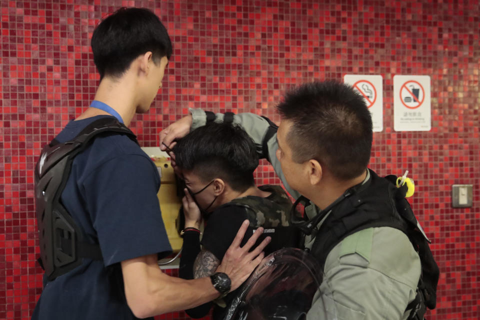 Police remove the face mask of a protesters after he blocked train door at a subway station in Hong Kong, on Monday, Sept. 2, 2019. Hong Kong has been the scene of tense anti-government protests for nearly three months. The demonstrations began in response to a proposed extradition law and have expanded to include other grievances and demands for democracy in the semiautonomous Chinese territory. (AP Photo/Jae C. Hong)