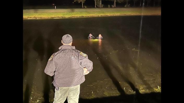 Two members of the Flagler County Sheriff’s Office Dive Team hover over the site of the vehicle while checking to make sure there are no passengers left inside.