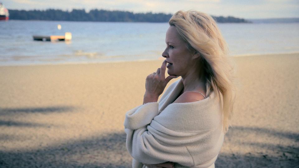 A woman stands alone on the beach