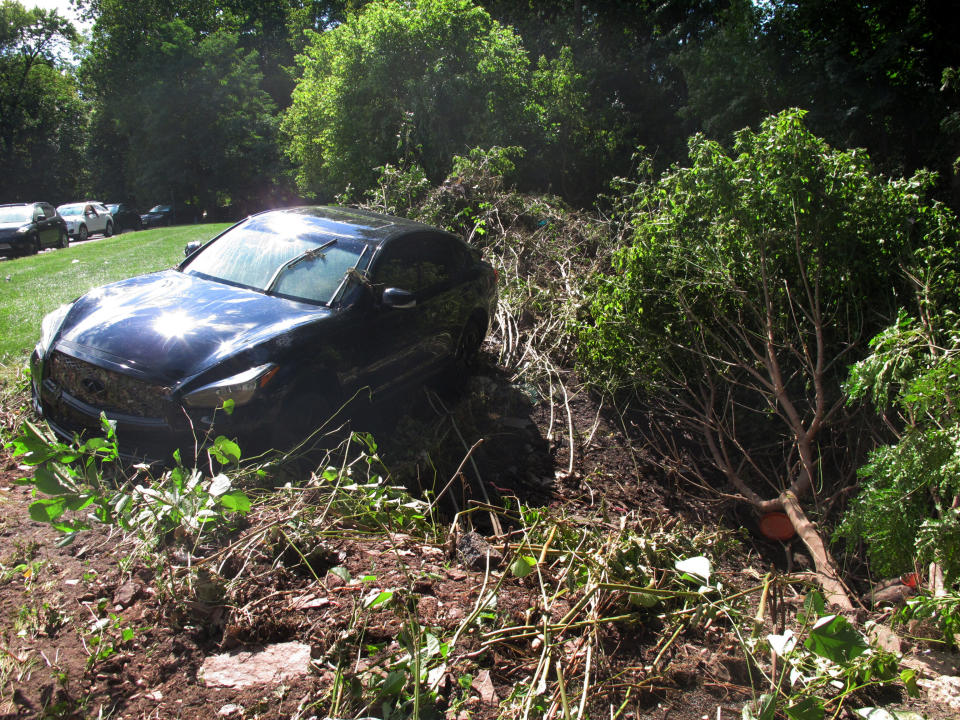 A car that was that was swept onto the banks of the Raritan River by the remnants of Tropical Storm Ida, remains in the area in Piscataway N.J, on Saturday, Sept. 4, 2021. (AP Photo/Wayne Parry)