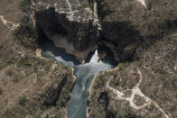 A tourist boat navigates through a canyon in Furnas Lake, near Capitolio City, Brazil, Sept. 2, 2021. A massive slab of rock broke away on Saturday, Jan. 8, 2022, from the canyon wall and and toppled onto pleasure boaters killing at least two people and injuring dozens at the popular tourist destination in Minas Gerais state. (AP Photo/Andre Penner)