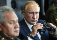 FILE - Russian President Vladimir Putin, right, holds a binoculars as Russian Defense Minister Sergei Shoigu sits near watching the joint strategic exercise of the armed forces of the Russian Federation and the Republic of Belarus Zapad-2021 at the Mulino training ground in the Nizhny Novgorod region, Russia, Monday, Sept. 13, 2021. With his room for maneuver narrowing quickly amid Russian military defeats in Ukraine, Putin has signaled that he could resort to nuclear weapons to protect the Russian gains in Ukraine - the harrowing rhetoric that shattered a mantra of stability he has repeated throughout his 22-year rule. (Sergei Savostyanov, Sputnik, Kremlin Pool Photo via AP, File)