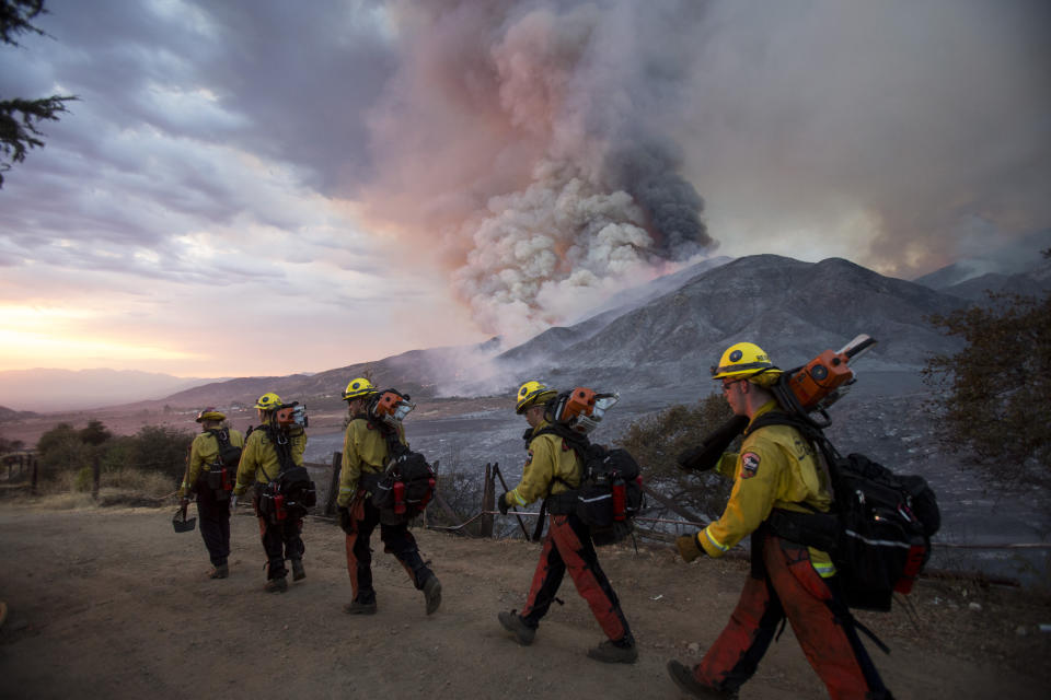 Members of firefighters walk in line during a wildfire in Yucaipa, Calif., Saturday, Sept. 5, 2020. Three fast-spreading California wildfires sent people fleeing Saturday, with one trapping campers at a reservoir in the Sierra National Forest, as a brutal heat wave pushed temperatures into triple digits in many parts of state.(AP Photo/Ringo H.W. Chiu)