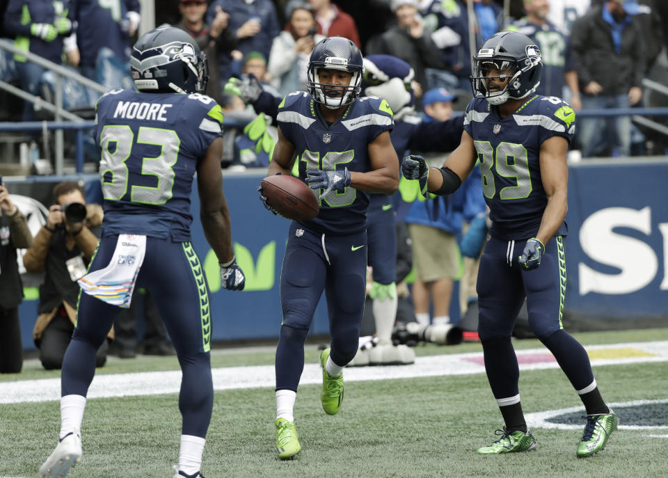 Seattle Seahawks wide receiver Tyler Lockett, center, does a "jump rope" celebration with wide receiver David Moore, left, and wide receiver Doug Baldwin, right, after making a catch for a touchdown against the Los Angeles Rams during the first half of an NFL football game, Sunday, Oct. 7, 2018, in Seattle. (AP Photo/Elaine Thompson)