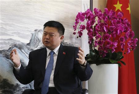 Wang Jing, Chairman and CEO of Xinwei Telecom Enterprise Groups and Chairman and CEO of HK Nicaragua Canal Development Investment Co. Ltd. (HKND), gestures in front of a Chinese national flag during an interview with Reuters in Xinwei Telecom's headquarters in Beijing, April 28, 2014. REUTERS/Barry Huang